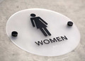 Round restroom signs with black stand offs - stylish bathroom signage